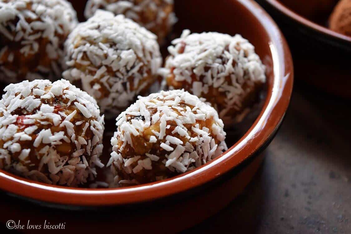 A bowl of unsweetened shredded coconut covered Greek Yogurt Goji Berry Almond Date Energy Bites