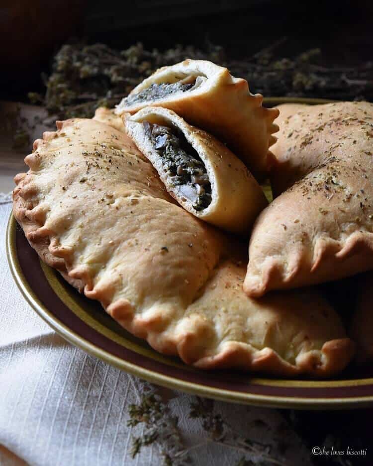 A spinach calzone cut in half on a plate. 