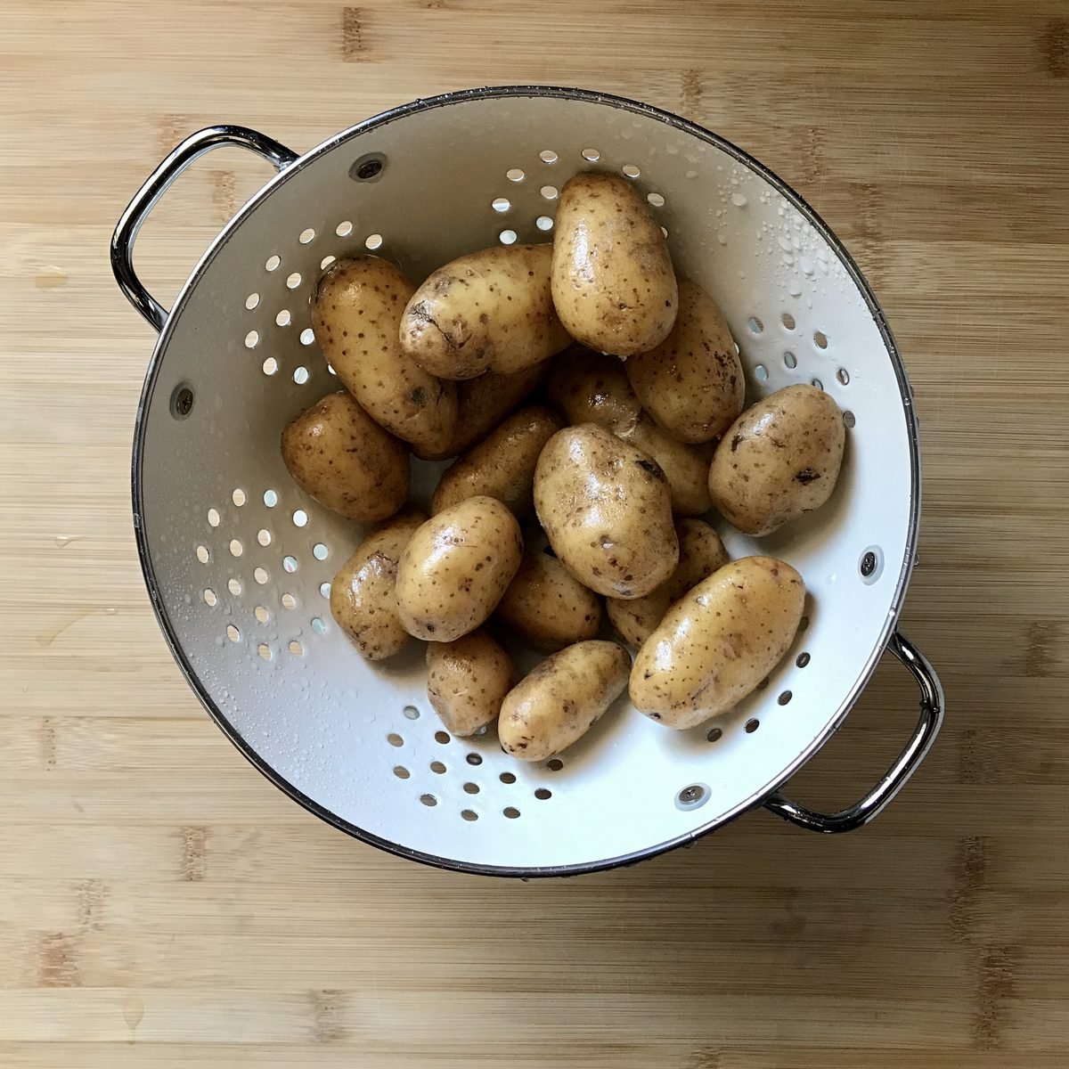 Creamer potatoes in a white colander.