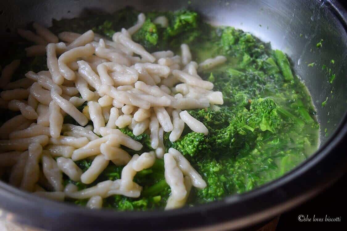 Combination of the broccoli rabe and the cavatelli in a pot.