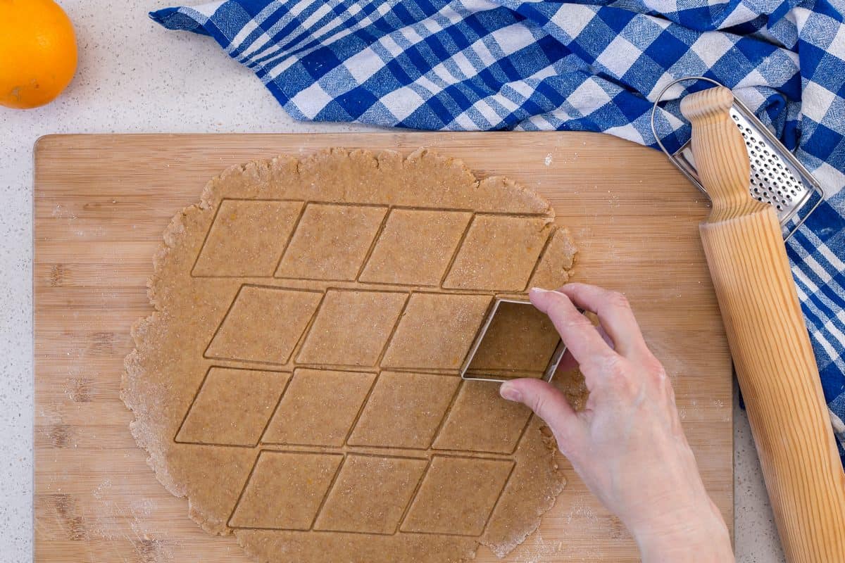 A cookie cutter is being used to cut out shapes from the rolled out dough.