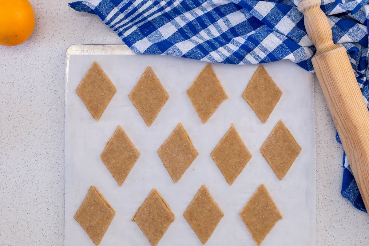 The cut out shapes are placed on a parchment lined cookie tray.