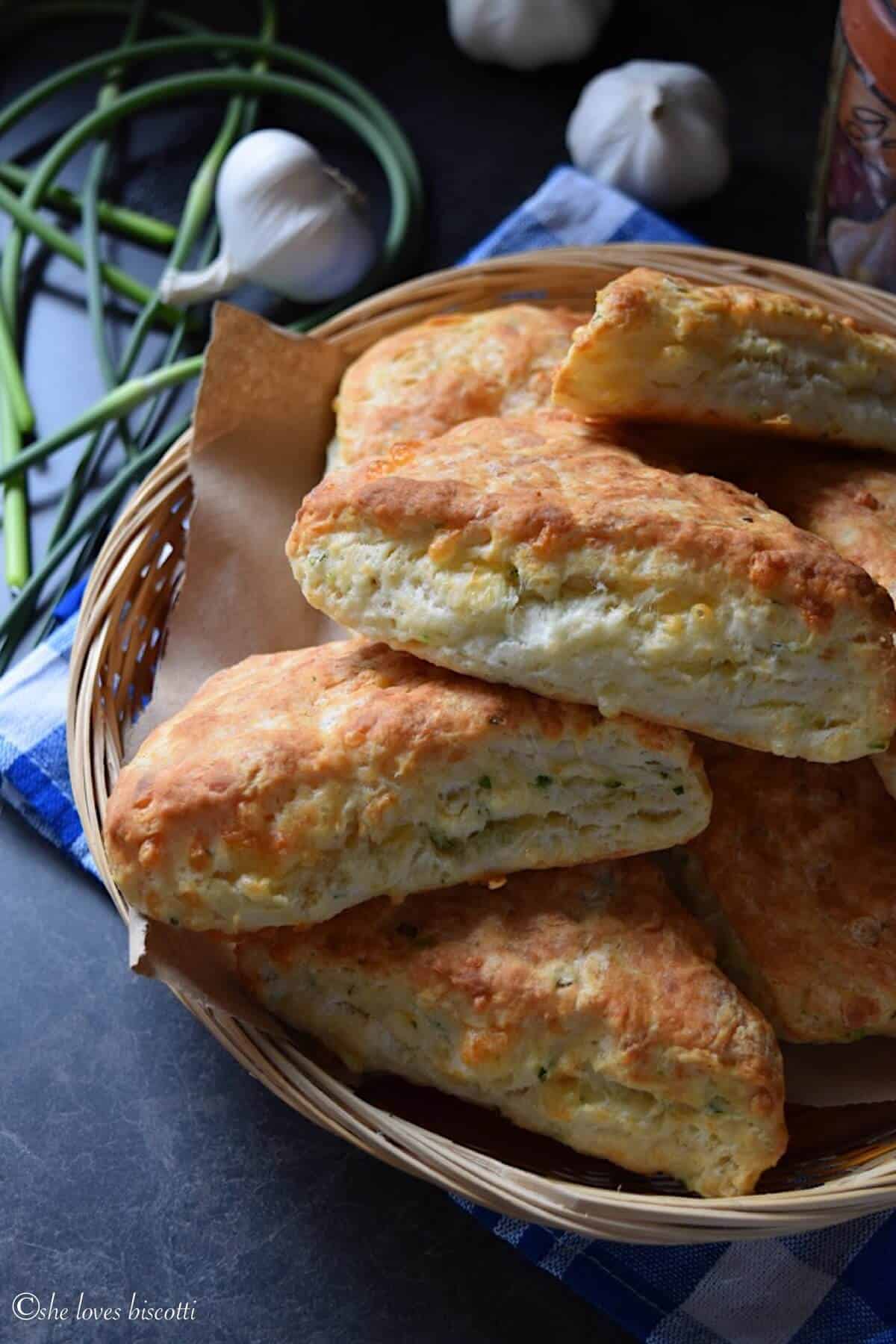 Cheddar Biscuits made with garlic scapes in a wicker basket.