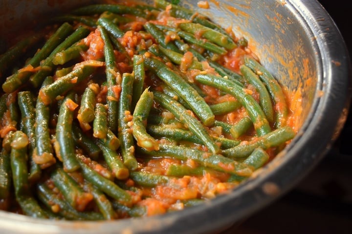 Stewed tomatoes and beans combined in the pan.