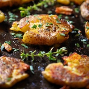 Smashed potatoes on a roasting pan.