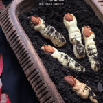 Witch fingers cookies scattered in chocolate crushed graham crackers. (to resemble dirt).