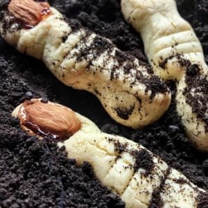 Witch finger cookies scattered in edible dirt.