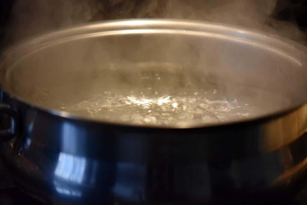 The first step to blanching almonds -a pot of boiling water is brought to a rapid boil.