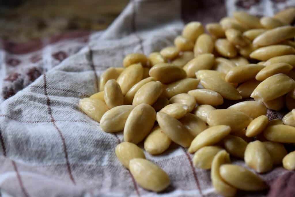 Blanched almonds laid out on a tea towel to dry.