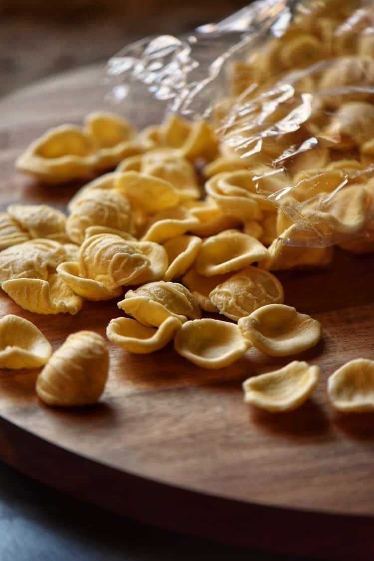 The dry form of the orecchiette pasta on a wooden board.
