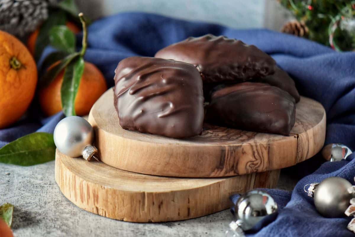 A few Italian Mustaccioli cookies placed on a wooden board.