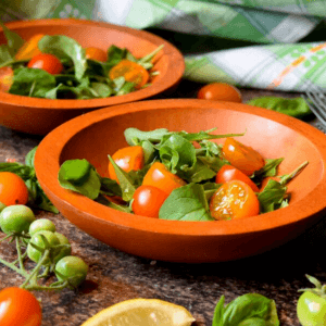 A bowl of cherry tomato and arugula salad.
