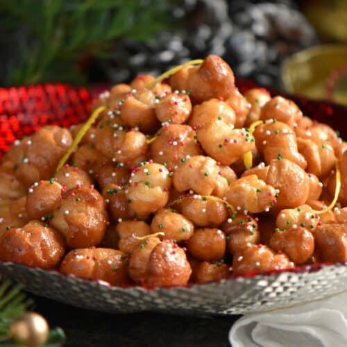 Italian honey balls in a red bowl.