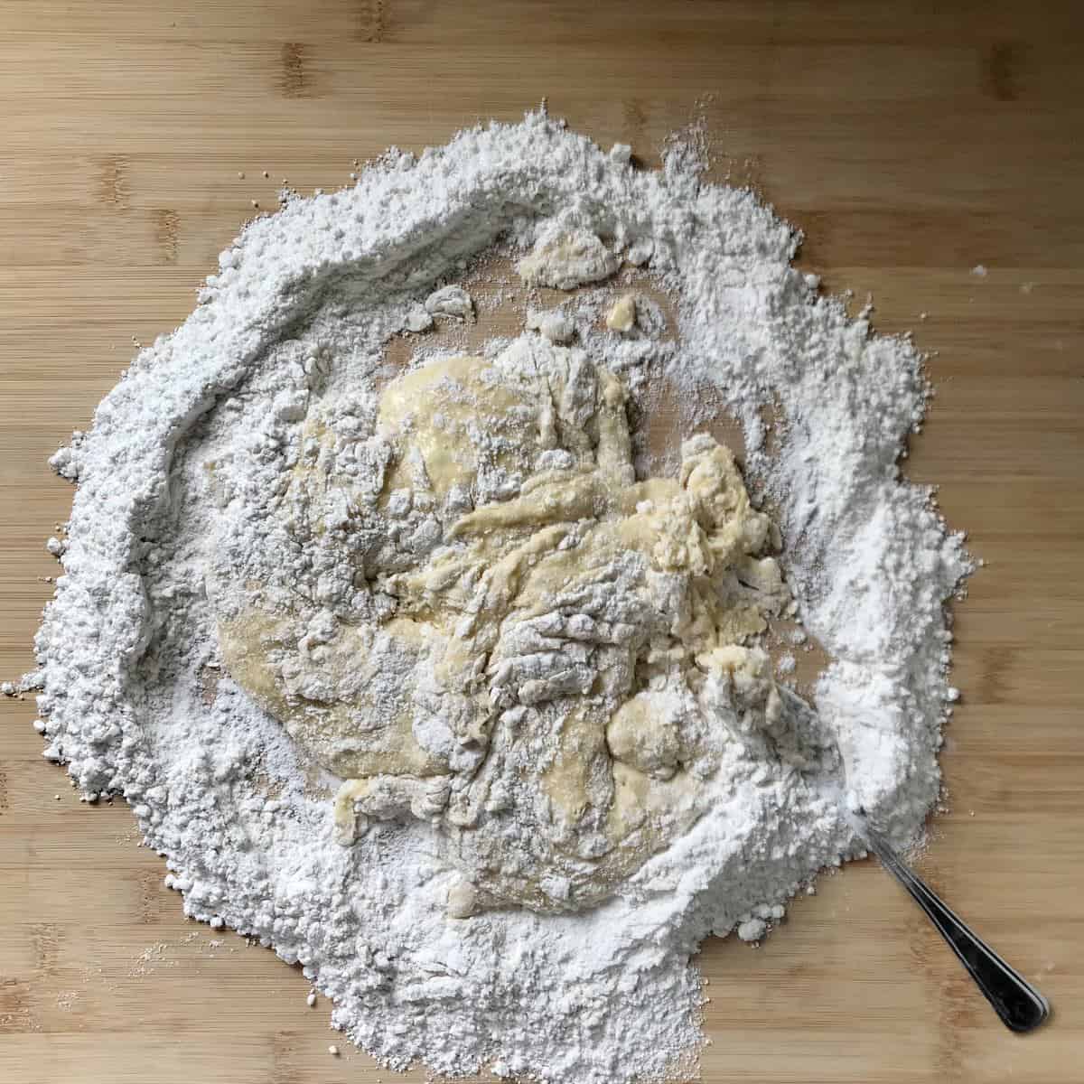 The dough to make struffoli on a wooden board.
