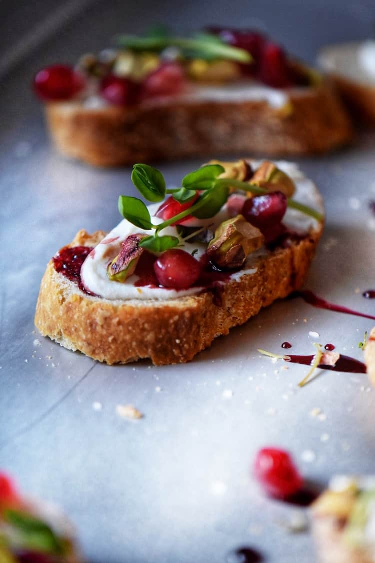 The completed Whipped Ricotta Pomegranate Crostini Recipe on a tray.