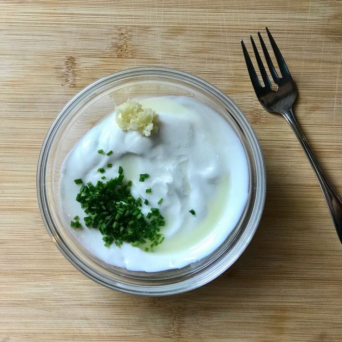 Ingredients to make garlic yogurt sauce in a bowl.