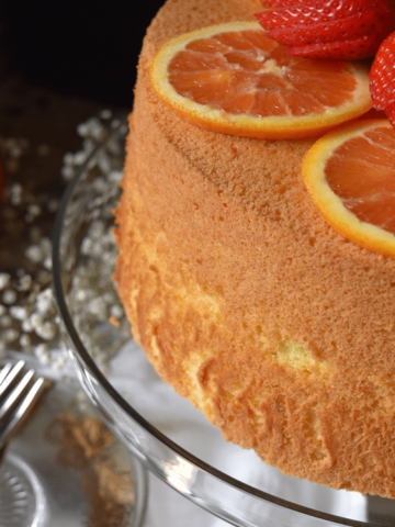 The Orange Chiffon Cake is is a cake platter decorated with sliced oranges.
