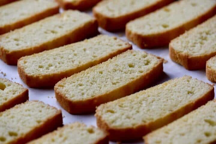 Sliced anise biscotti, all lined up on a baking tray, ready for the second bake.