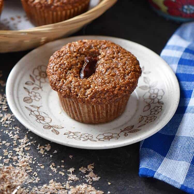 A close up shot of a bran muffin on a plate.