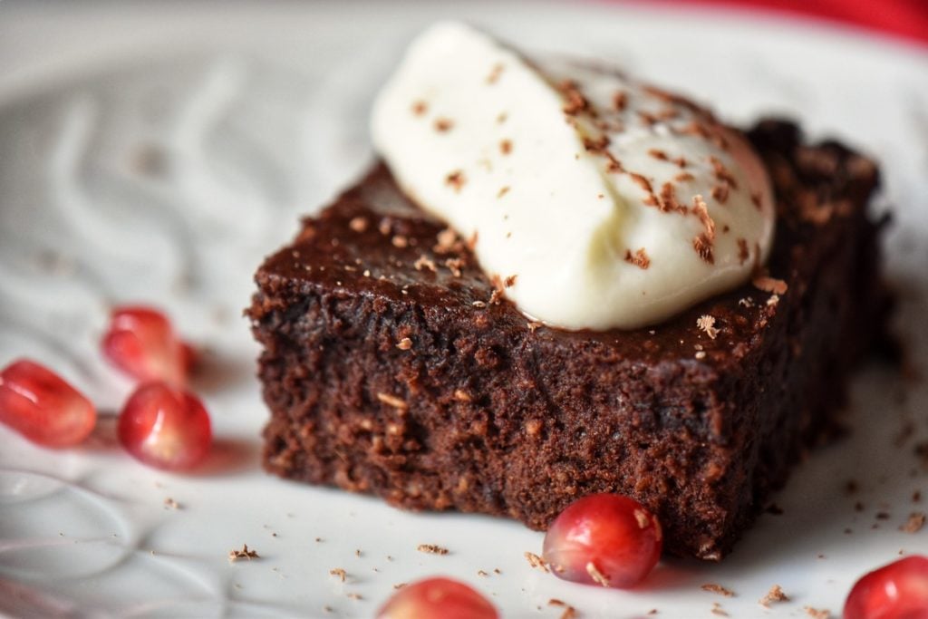 A piece of healthy chocolate brownie topped with ricotta.