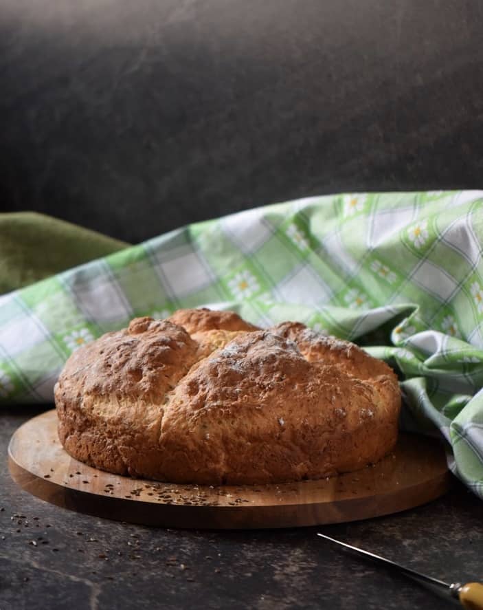 Non traditional soda bread fresh out of the oven on a wooden cutting board.