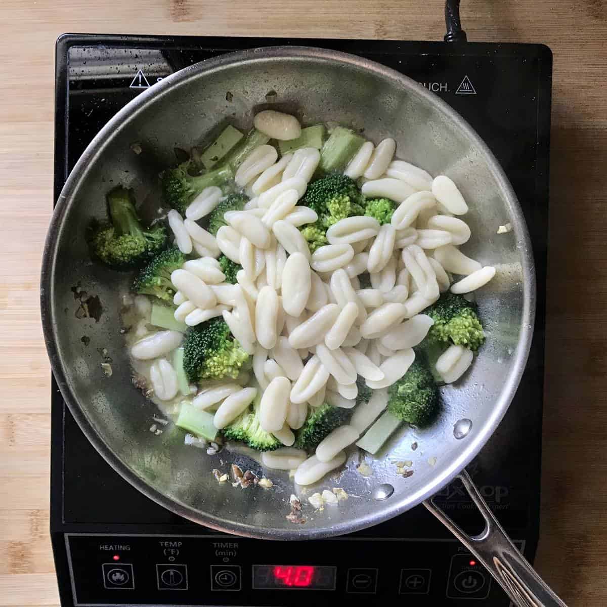Combining the broccoli and cavatelli with the sauteed garlic and anchovies.