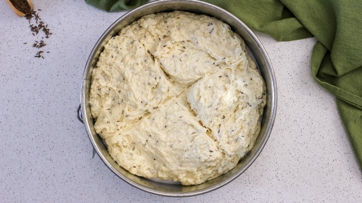 An overhead shot of the Irish soda bread in the sprinform pan before being baked with a distinctive X on the surface.