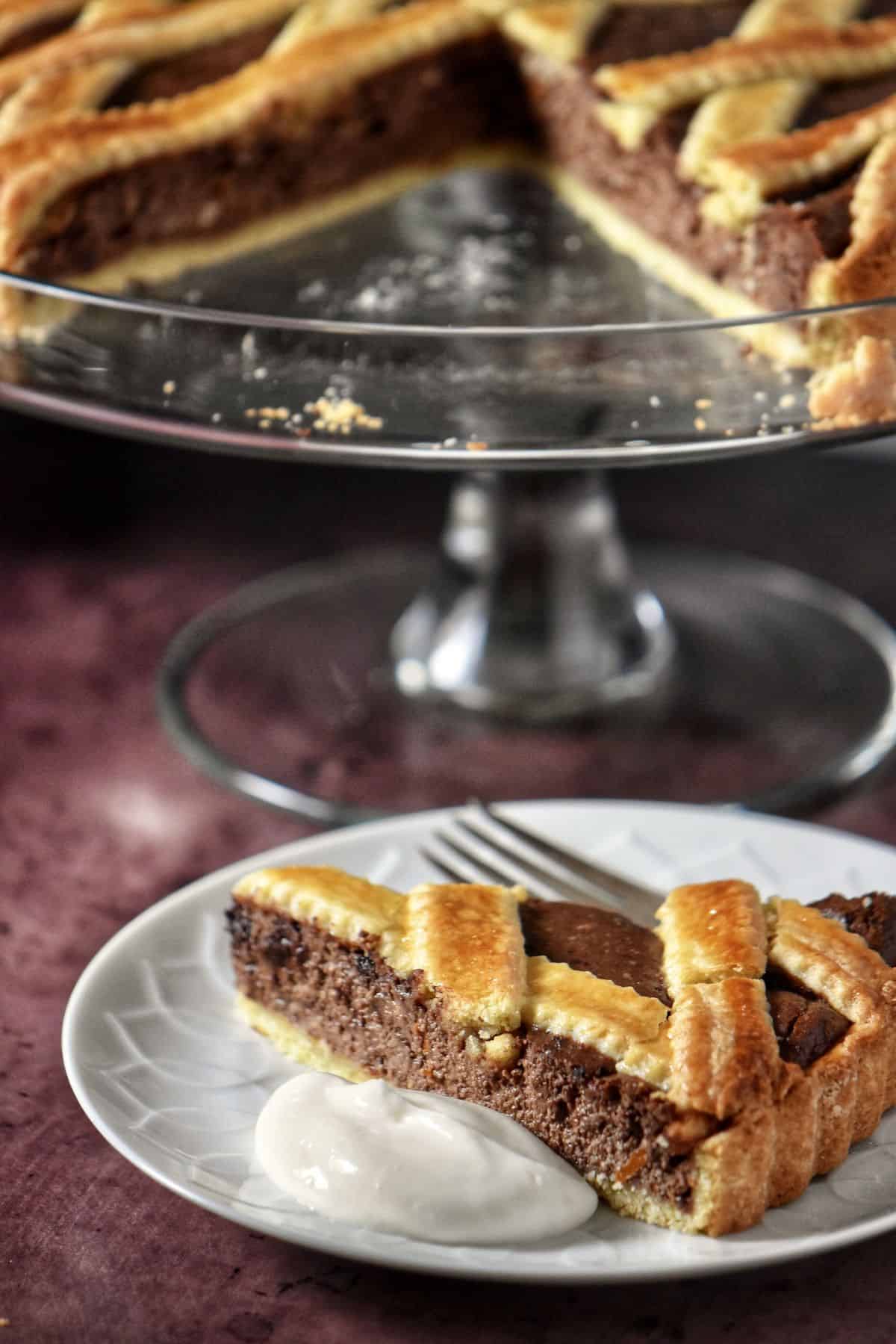 A slice of ricotta tart with a dollop of ricotta cream on a white plate.