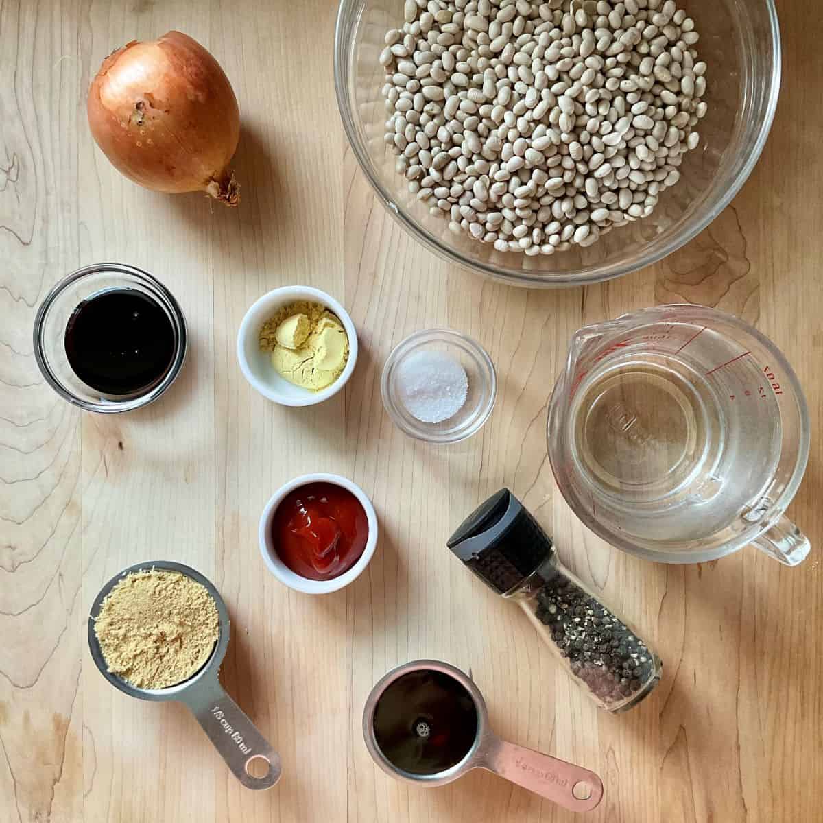 Ingredients to make baked beans on a wooden board.