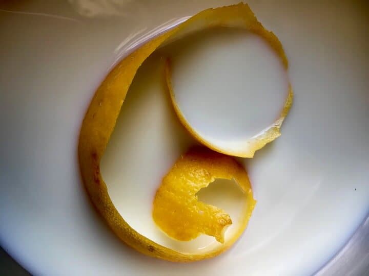 The addition of lemon peel to milk.