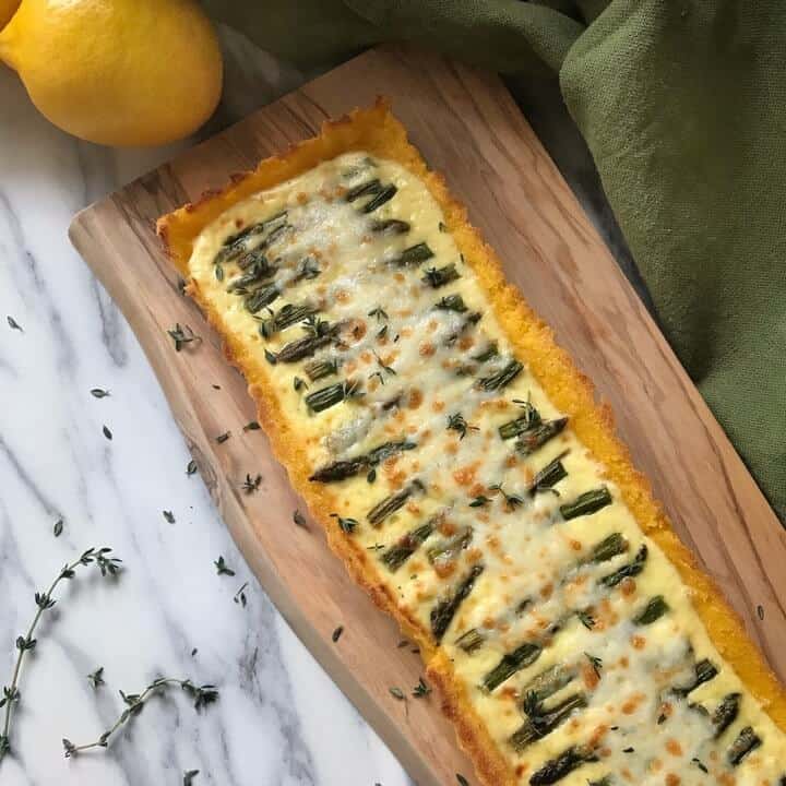 A square overhead image of the Asparagus Ricotta Tart on a wooden board.