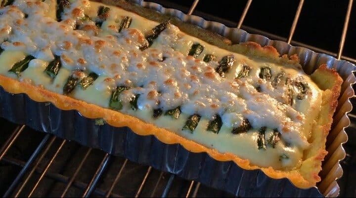 The bubbling mozzarella cheese of the Asparagus Ricotta Tart baking in the oven.