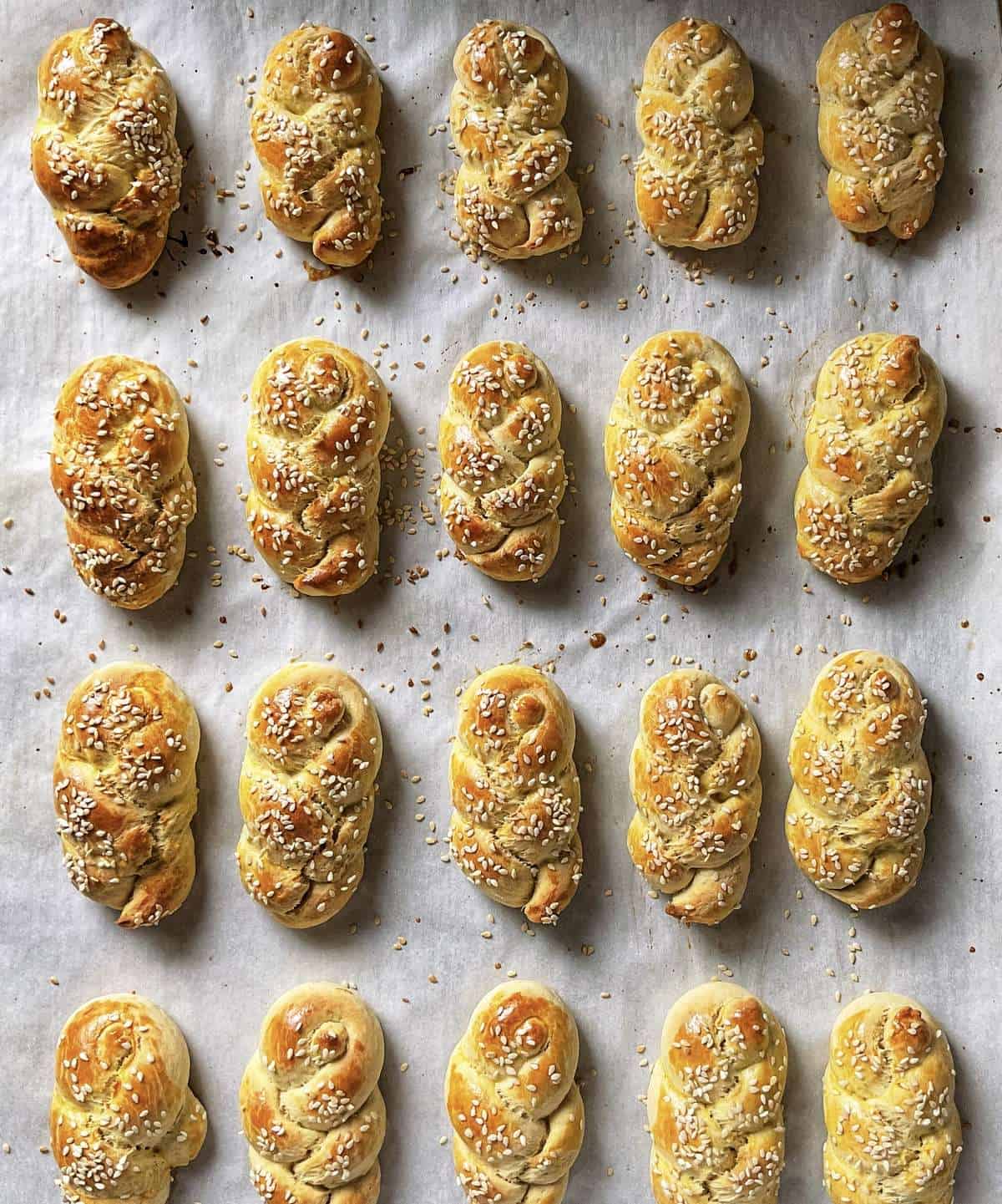 Koulourakia on a parchment lined cookie sheet. 