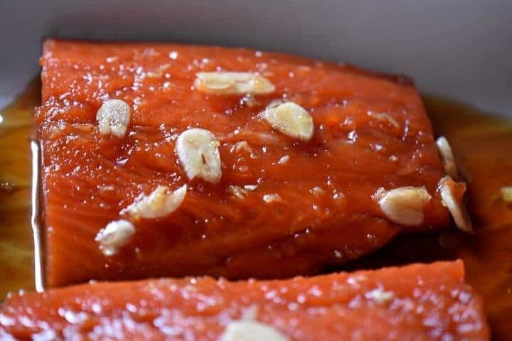 A close up of the garlic slivers on the salmon.
