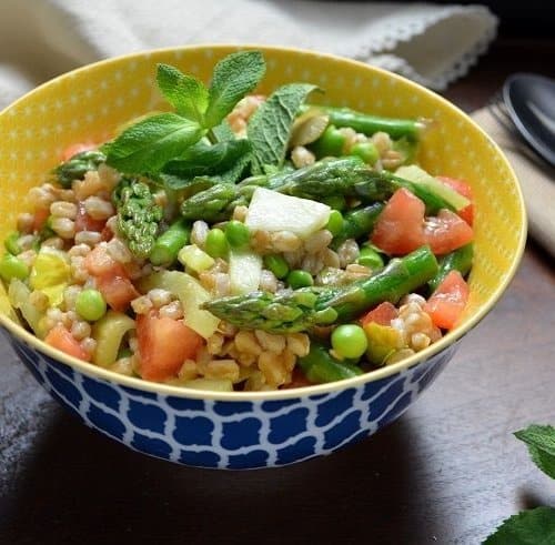 The colorful spring salad in a colorful yellow and blue patterned bowl.