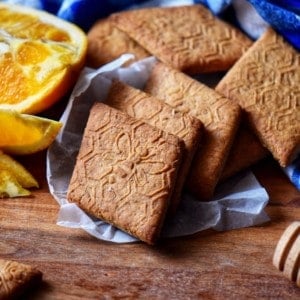 A stack of whole wheat cookies on a wooden board.