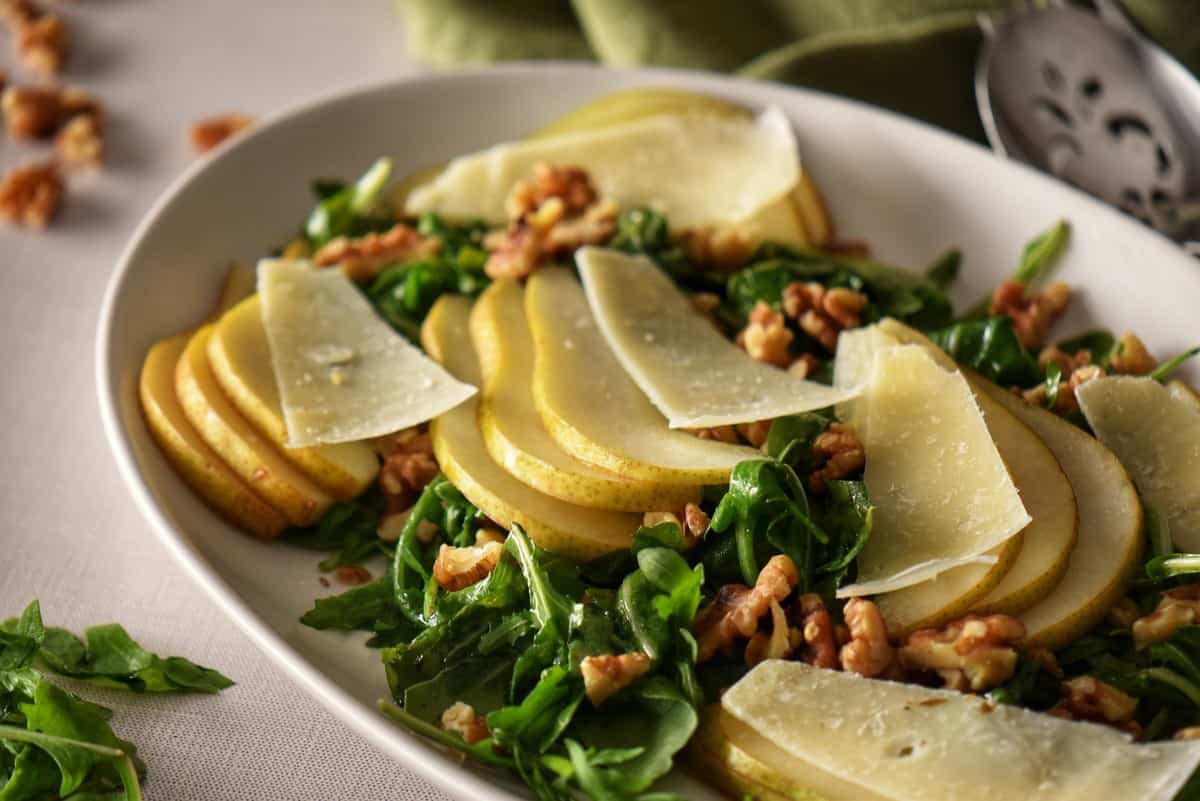 Thinly sliced pear, crunchy walnuts and salty Parmesan cheese top a dish of arugula.