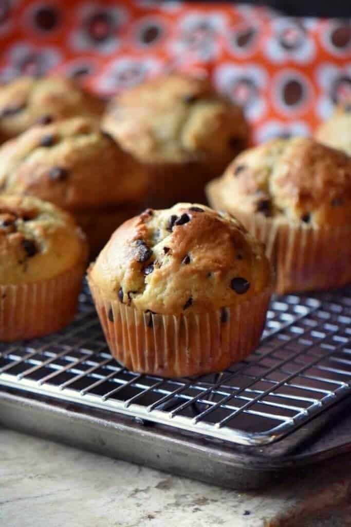 Bakery Style Chocolate Chip Muffins cooling off on a wire rack.