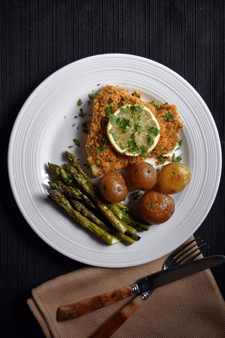 An overhead shot of the oven baked cod fish with asparagus and roasted potatoes.