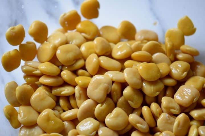 A close up of de-shelled lupini beans in a bowl.