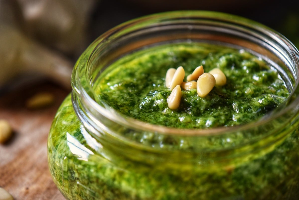 A close up of a jar of pesto sauce.