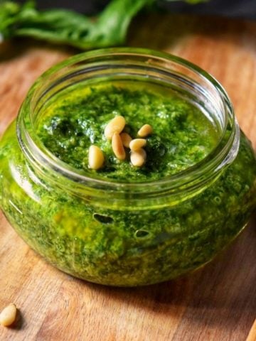 A small mason jar filled with basil pesto sauce for pasta.