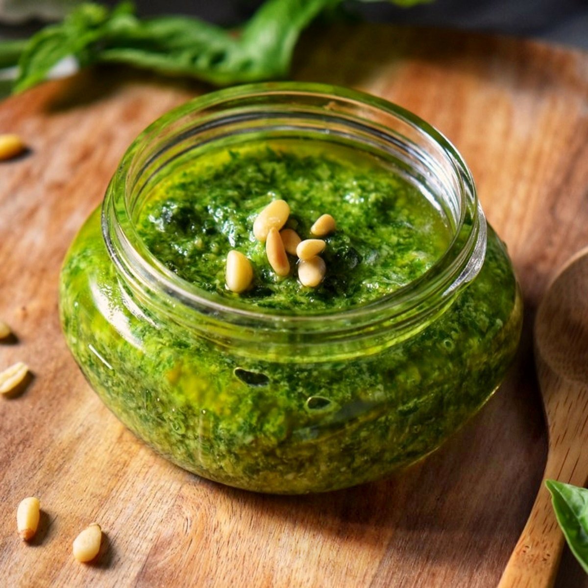 A small mason jar filled with basil pesto sauce for pasta.