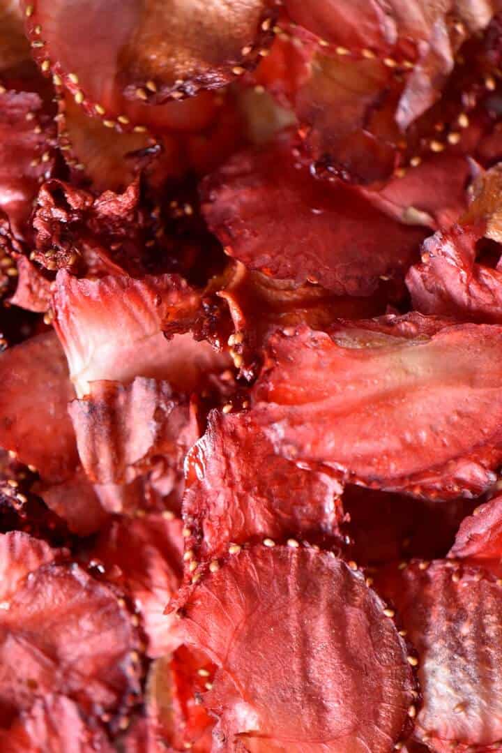 An overhead shot of bright red colored strawberry chips.