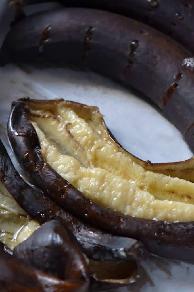 The soft interior of a baked banana is exposed.