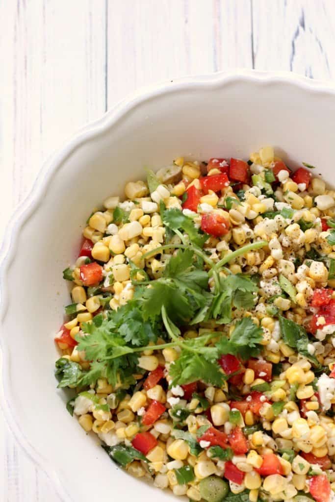 An overhead shot of a large bowl of sweet corn salad.
