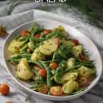 A colorful Italian potato salad made with garden fresh cherry tomatoes, green beans and new potatoes, sliced in half.