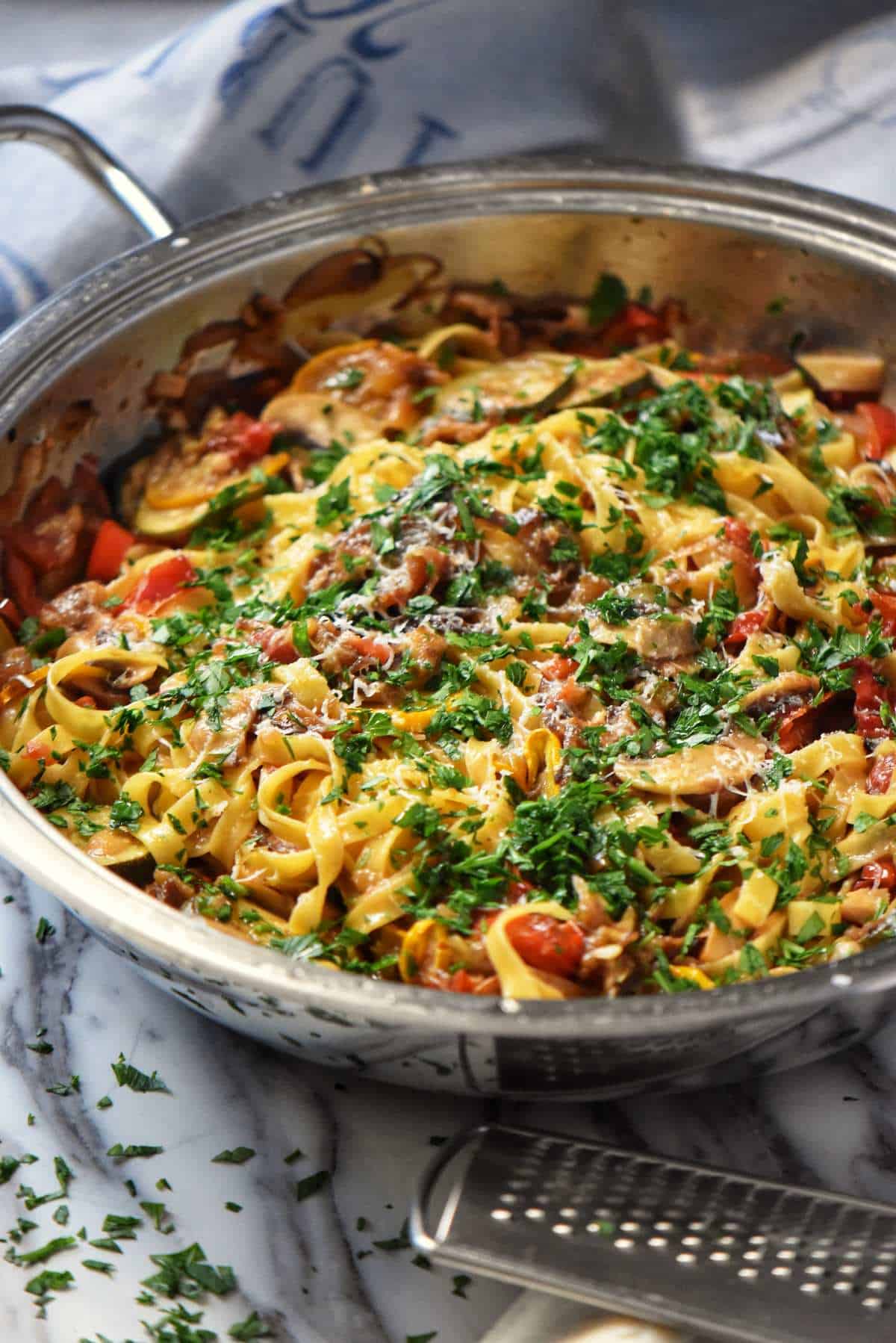 Roasted Vegetable Pasta combined together in a pan, with a sprinkle of minced Italian parsley.