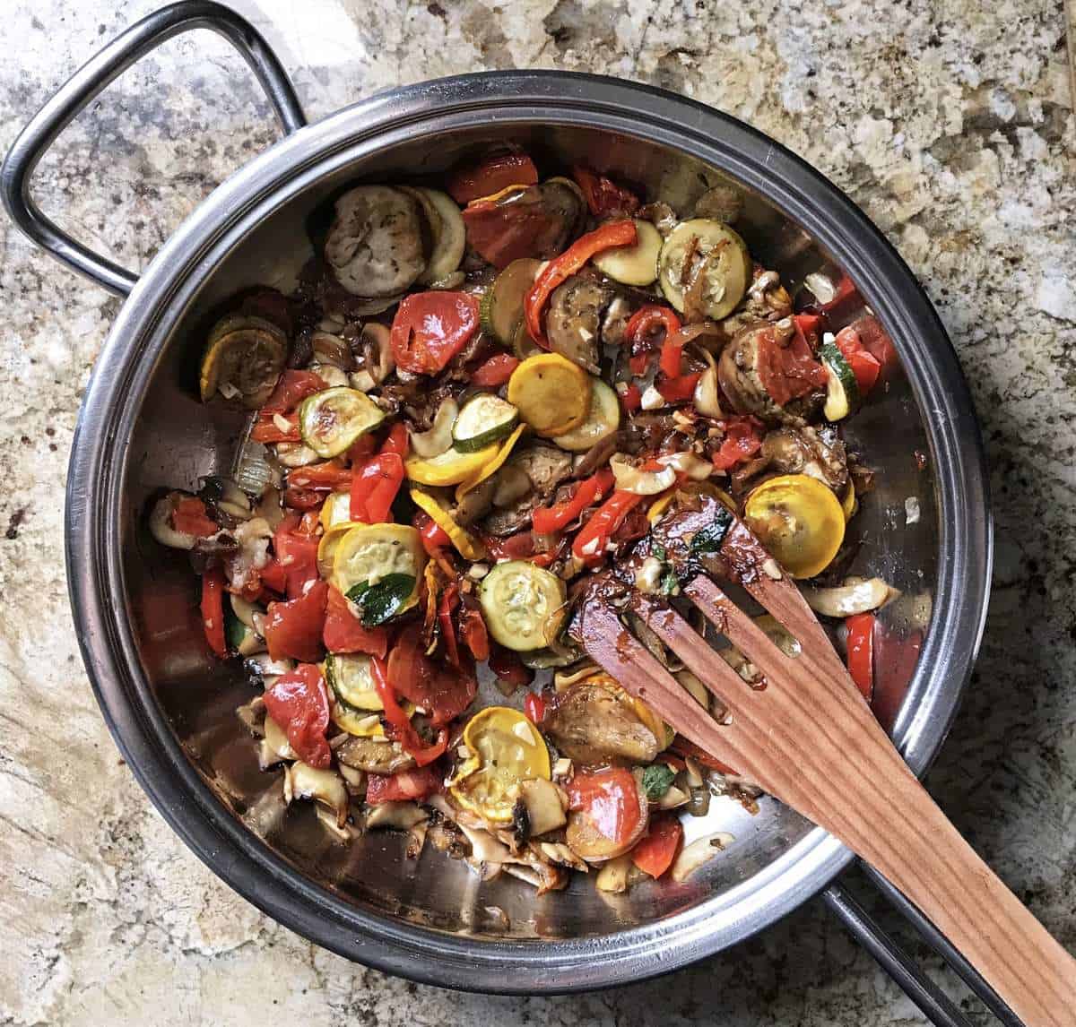 The addition of grilled vegetables to the pan of sauteed shallots and mushrooms.