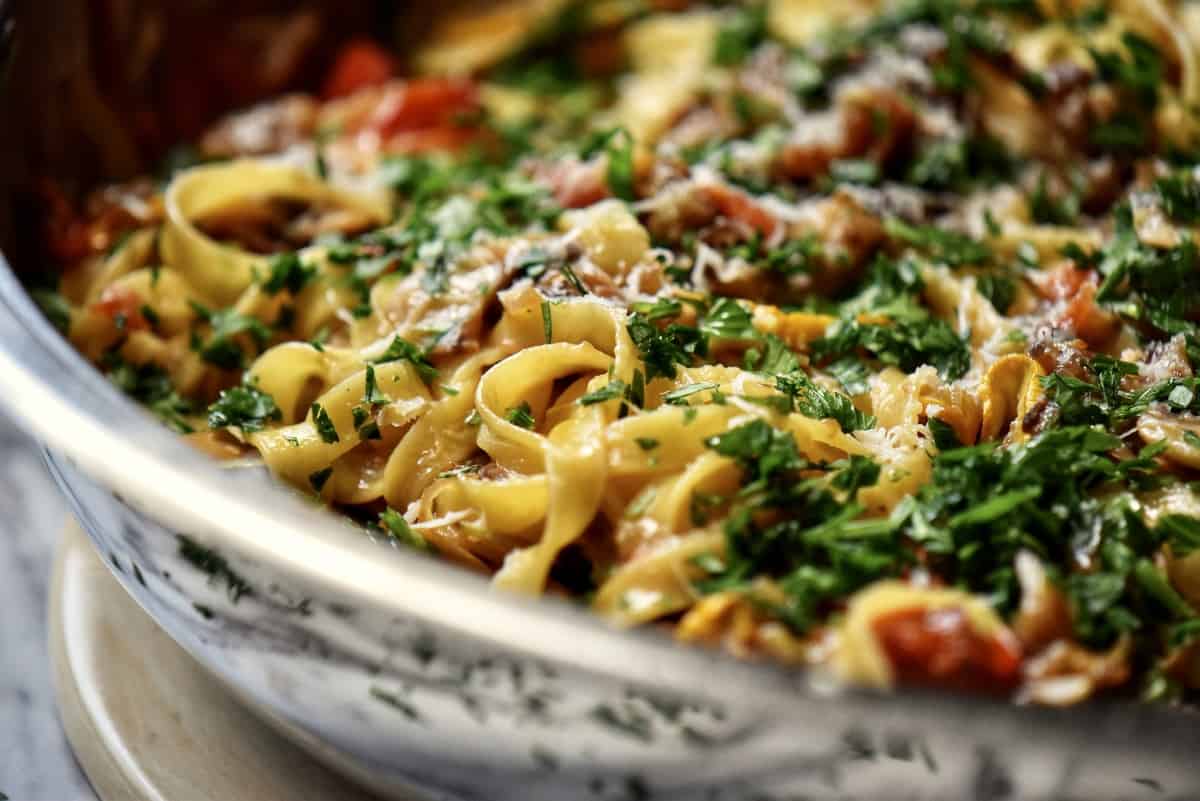 A close up shot of the pasta vegetable dish with lots of cheese and parsley sprinkled over the top. 